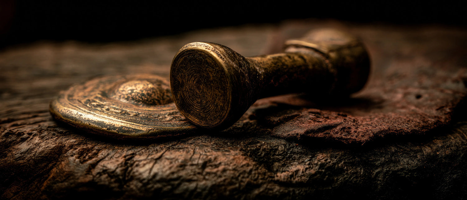 Bronze dumbbells on a wooden surface with a dark background