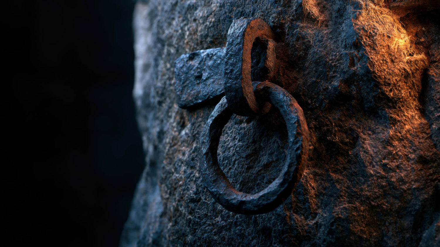 A dramatic, close-up photograph of an ancient, hand-forged iron hitching ring securely embedded in a rugged, deeply textured stone wall. The heavily weathered and rusted metal is illuminated by a striking contrast of cool shadows and warm, fiery ambient light, suggesting the glow of a nearby forge. This enduring historical detail perfectly evokes the rugged strength, hidden lore, and traditional English heritage that inspires Caracoda Equestrian's craftsmanship.